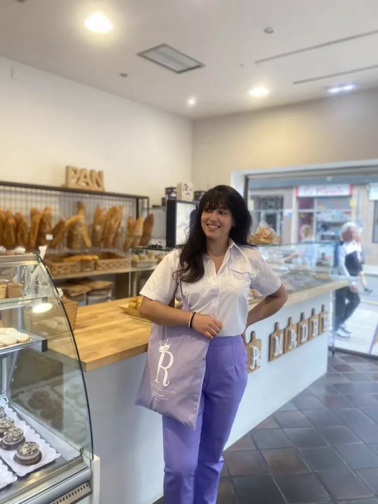 Jessyca mostrando una bolsa de tela con diseño de Reinas