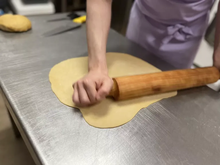 Persona estirandoo masa de pan con un rodillo